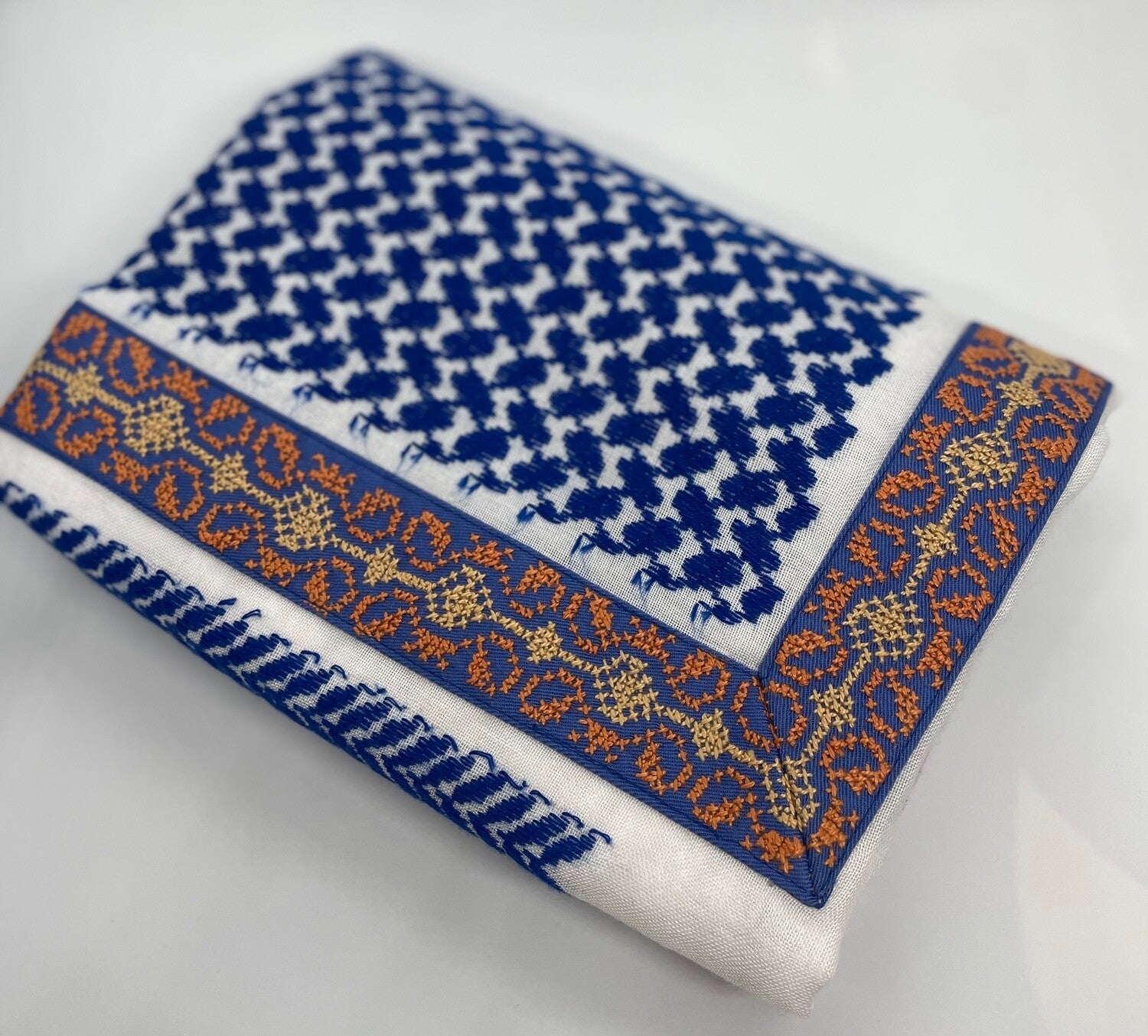 Folded fabric with blue and white pattern on a light gray background