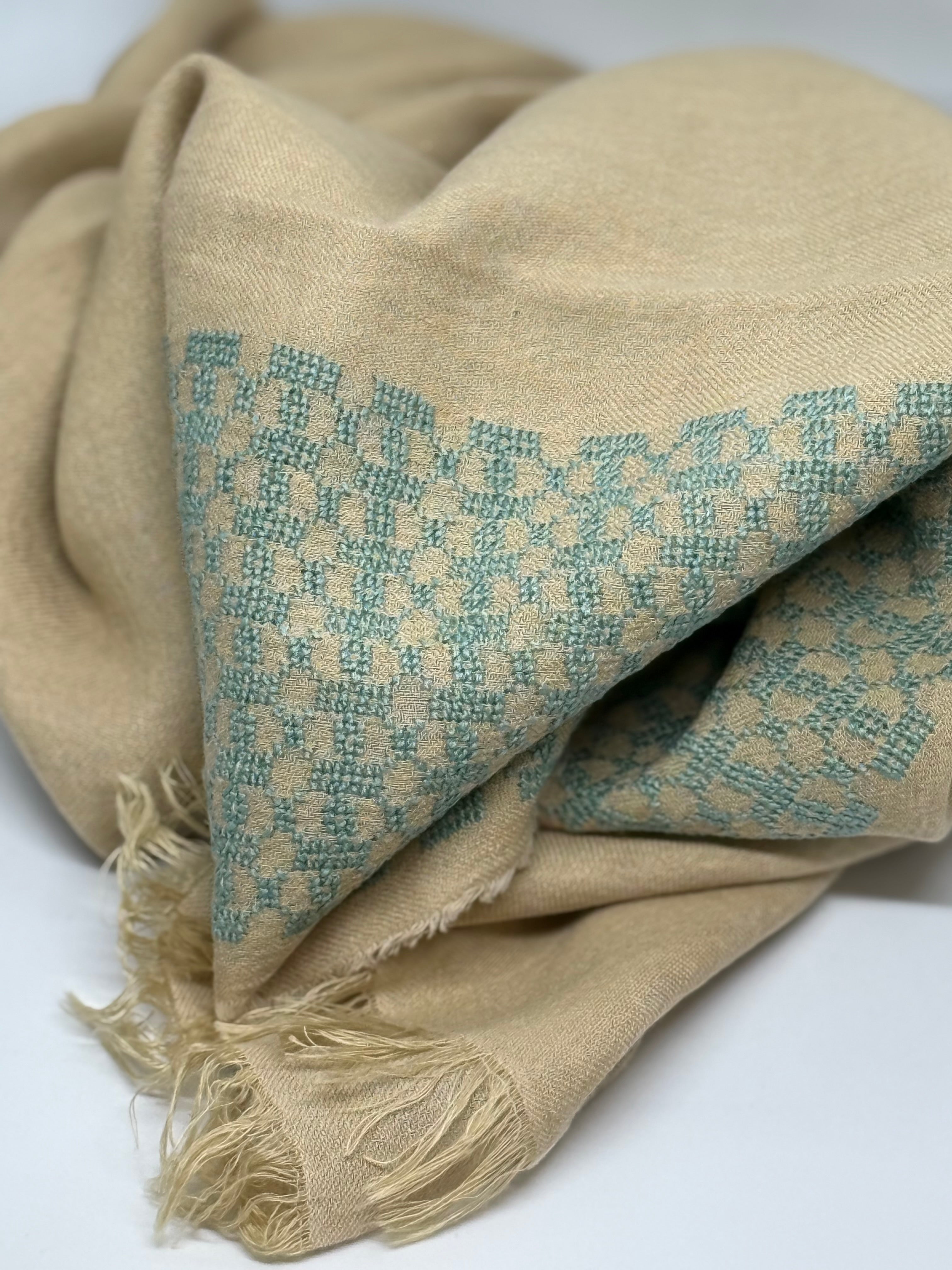 Beige fabric with teal geometric pattern on a white background