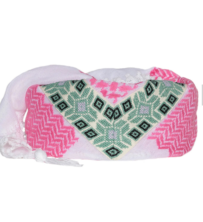 Pink and green patterned bag with white tassels on a white background