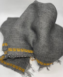 Grey linen shawl featuring a hand-embroidered rose pattern, crafted in Italy and Jordan.