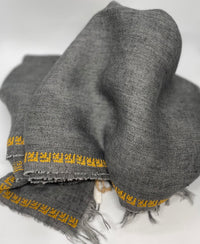 Grey linen shawl featuring a hand-embroidered rose pattern, crafted in Italy and Jordan.