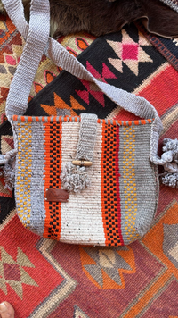 Handwoven crossbody bag crafted by Bedouin artisans using recycled yarn, featuring intricate patterns and an adjustable strap.