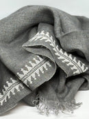 Gray fabric with white embroidery on a light gray background