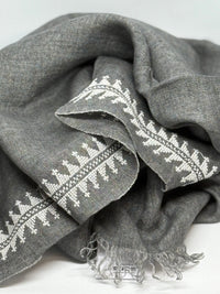 Gray fabric with white embroidery on a light gray background