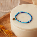 Blue beaded bracelet on a white box with a blurred background